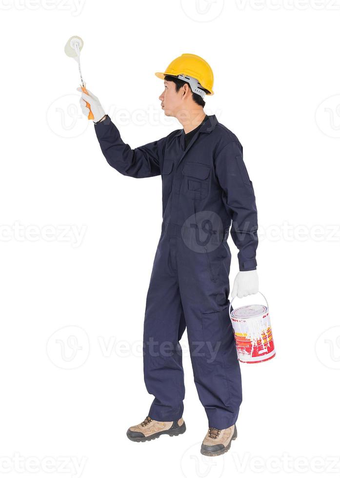Worker in a uniform using a paint roller is painting invisible wall photo