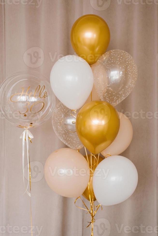 Decor for the celebration of the 30th anniversary. Helium balloons in gold, pink and white colors photo