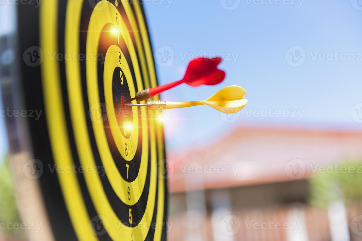 Two dart hit it's target on a red background, concept for success,darts motion blur. photo