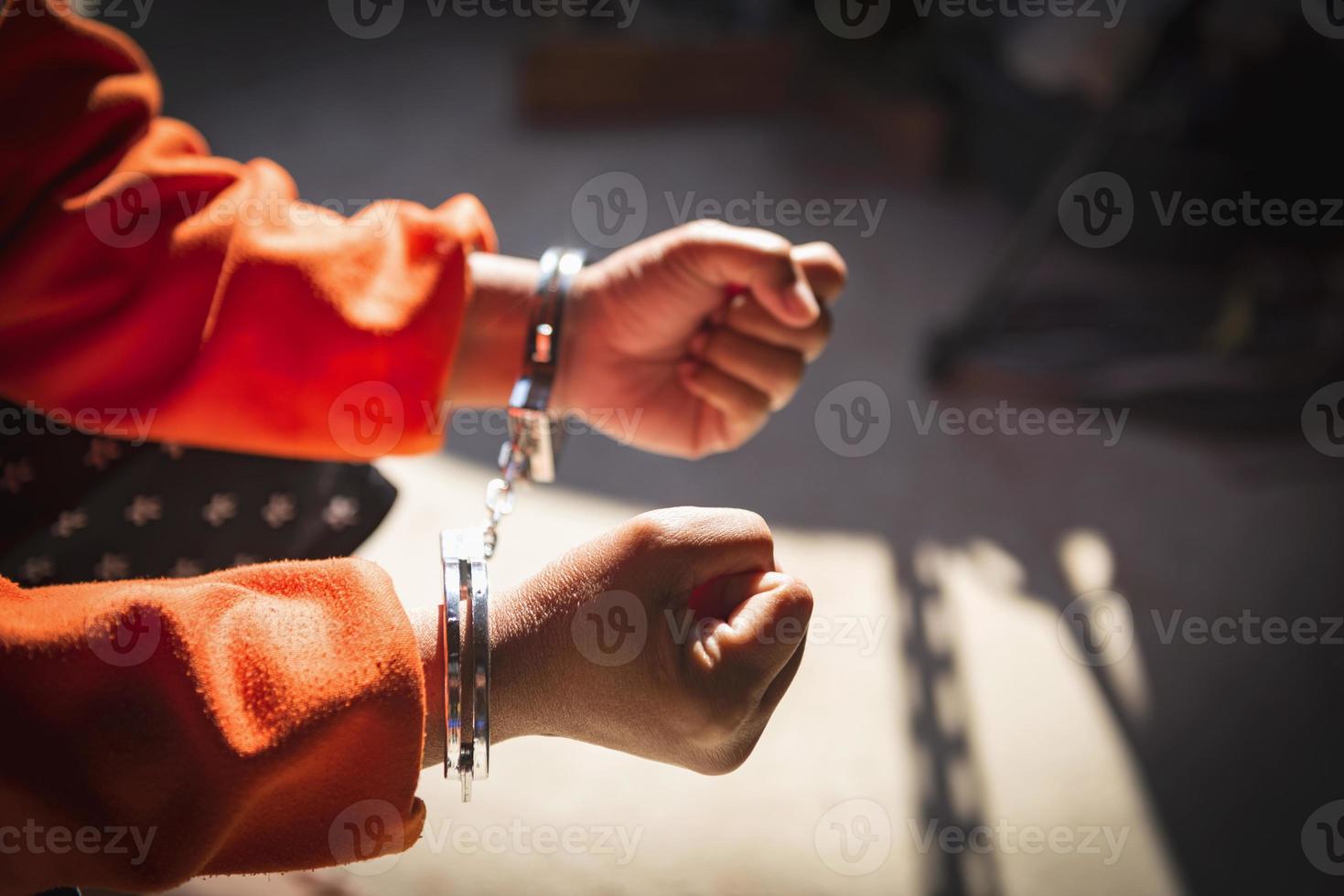 Desperate criminal man sitting on the floor in handcuffs. She arrested for robbery. photo