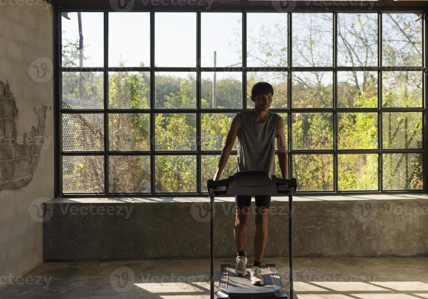 Man running in a gym on a treadmill concept for exercising, fitness and healthy lifestyle. photo