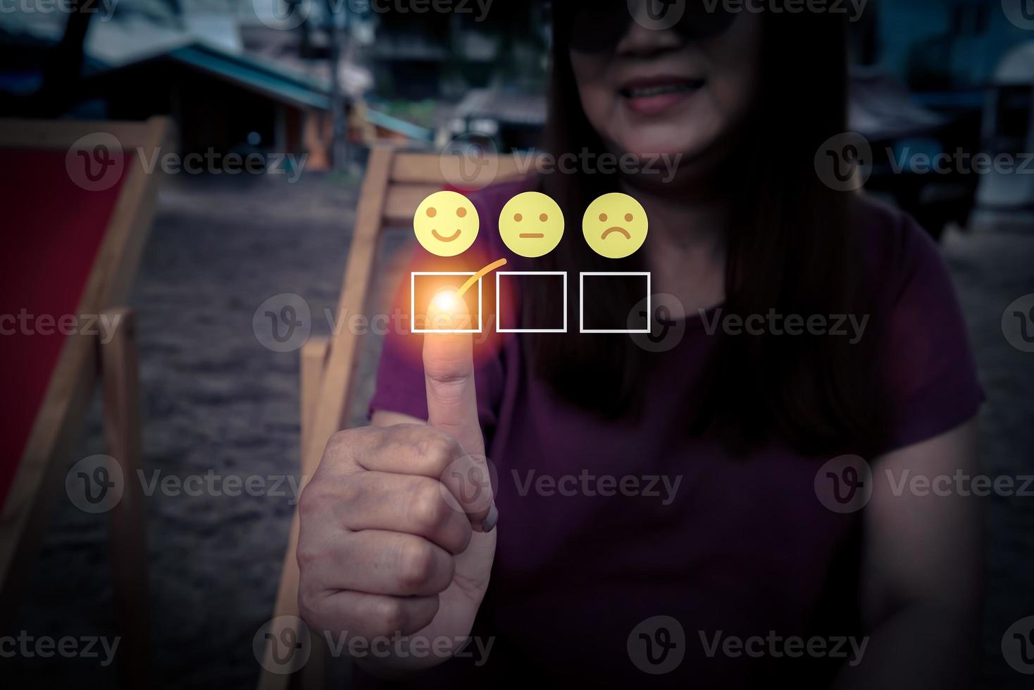 dedo del viajero de la mujer tocando y marca de verificación en la cara del icono de calificación de satisfacción de la sonrisa. foto