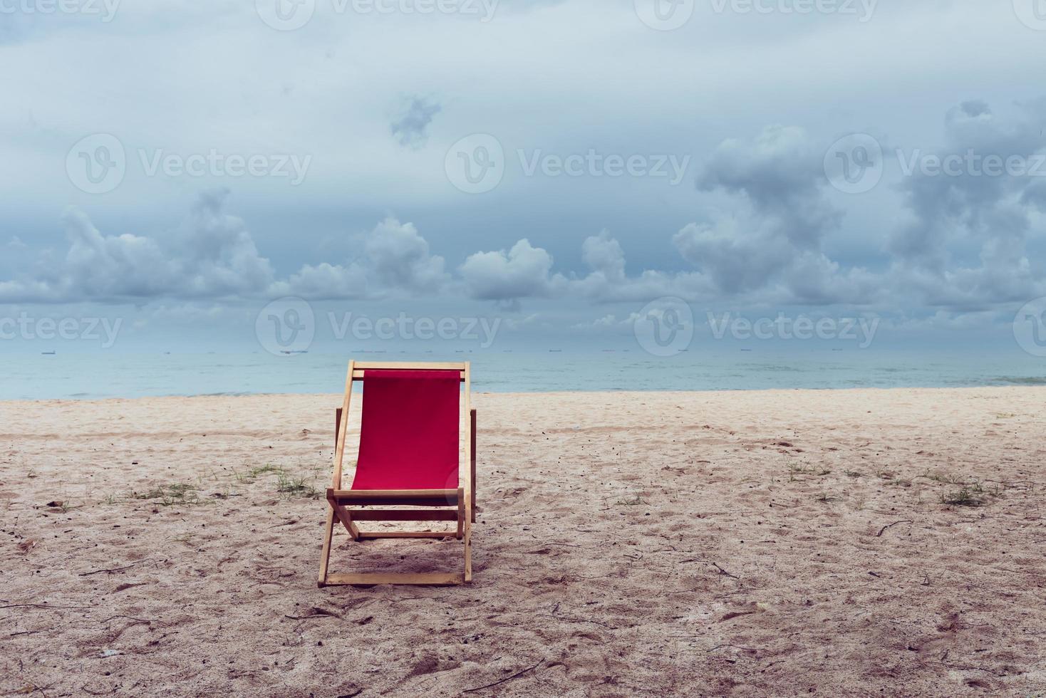 Empty outstanding red beach chair on the seashore, beach vacation and relaxing concept. photo