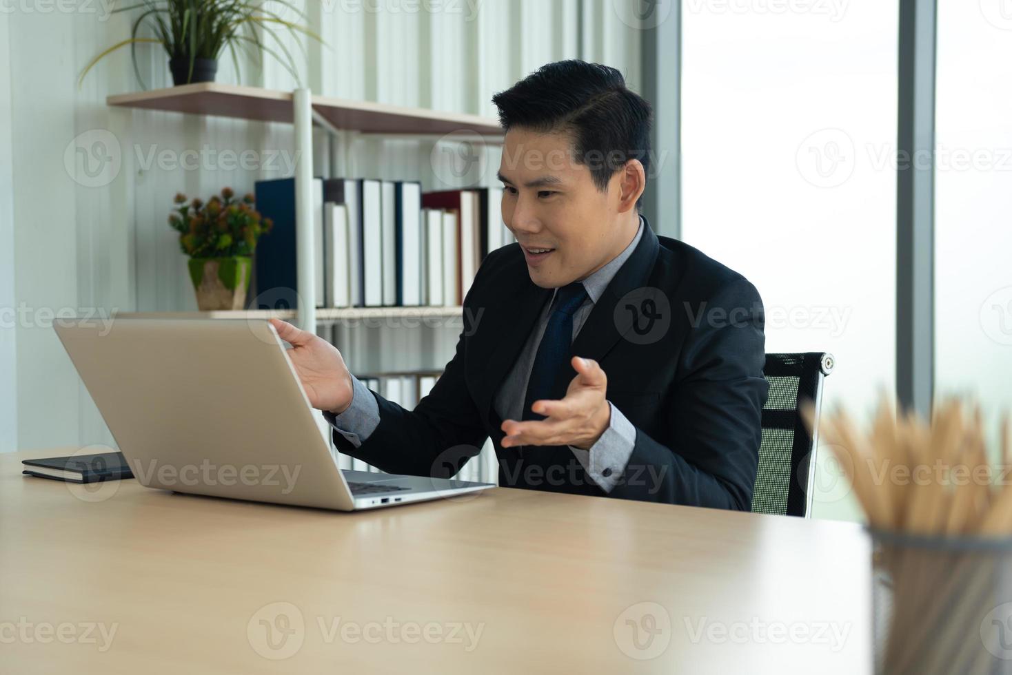 Online learning, Meeting, working and E learning concept. Casual Asian business man studying online course, meeting  via laptop computer in the office. photo