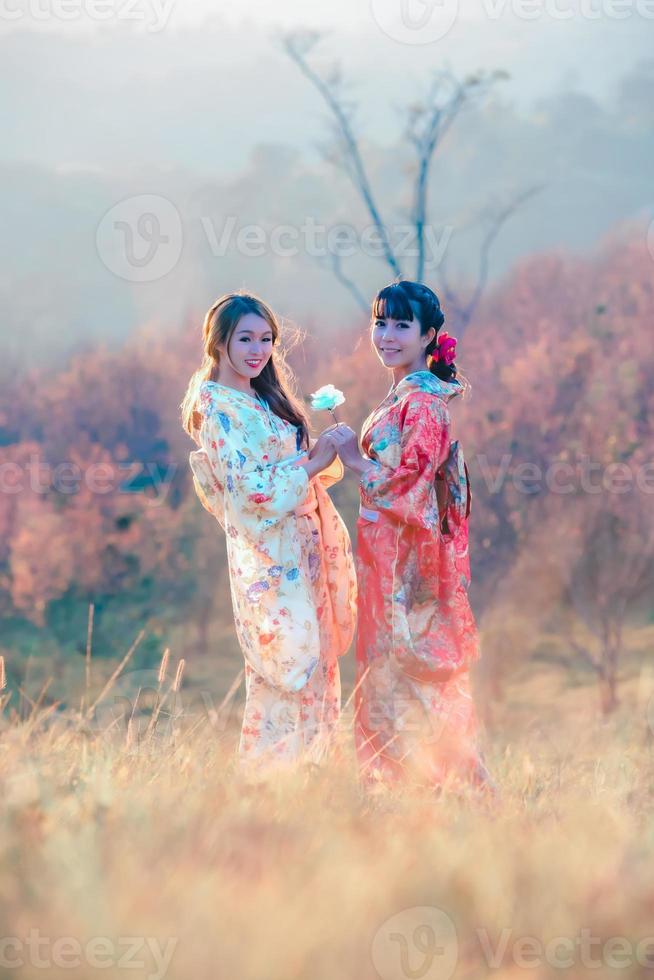 viajes y vacaciones en el concepto de japón, dos jóvenes asiáticas con kimono japonés tradicional y manos sosteniendo una hermosa rosa blanca, japón. foto