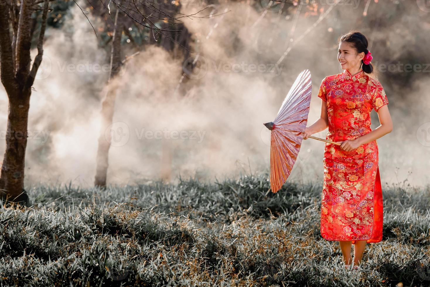 viajes, concepto de vacaciones en Japón, joven asiática con kimono japonés tradicional rojo y paraguas en el parque por la mañana. foto