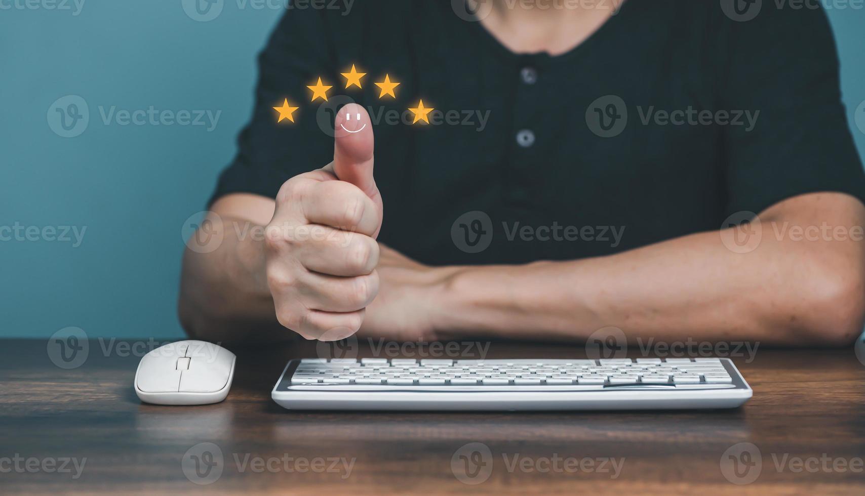 Young man showing thumbs up and giving positive five stars rating review for client's satisfaction service surveys, Customer evaluation feedback concept. photo