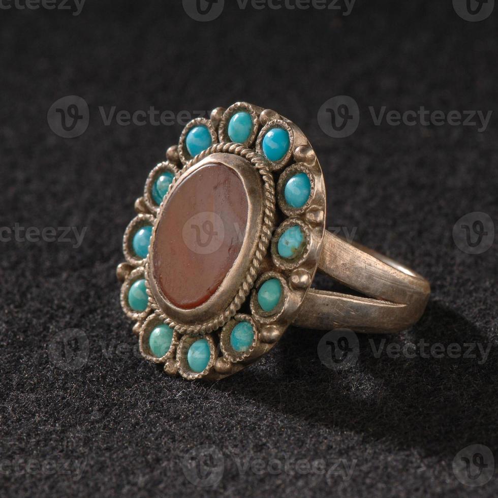 A Vintage, fancy ring with precious, colorful stone isolated on a black background photo