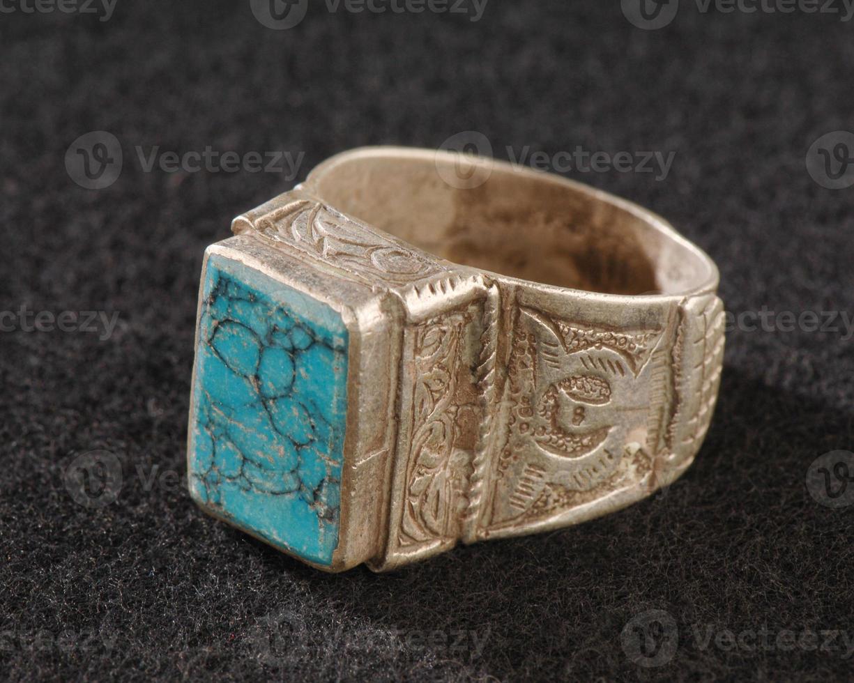 A vintage, fancy ring with precious, Emerald stone isolated on a black background photo