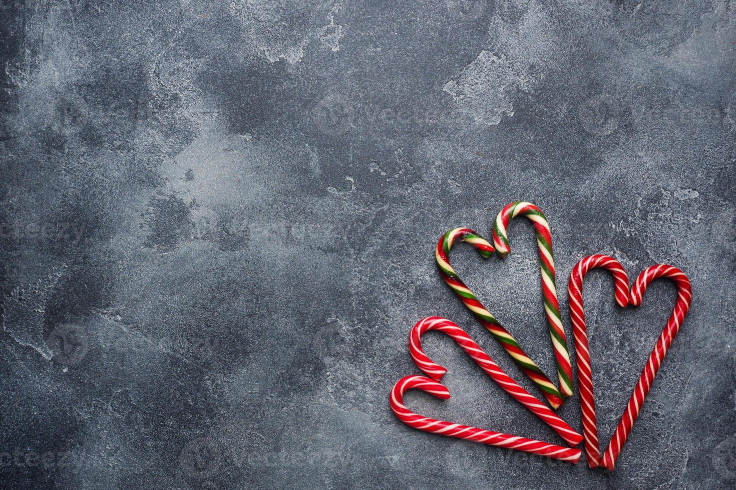 Christmas candy cane heart shaped on dark grey background with copy space. photo