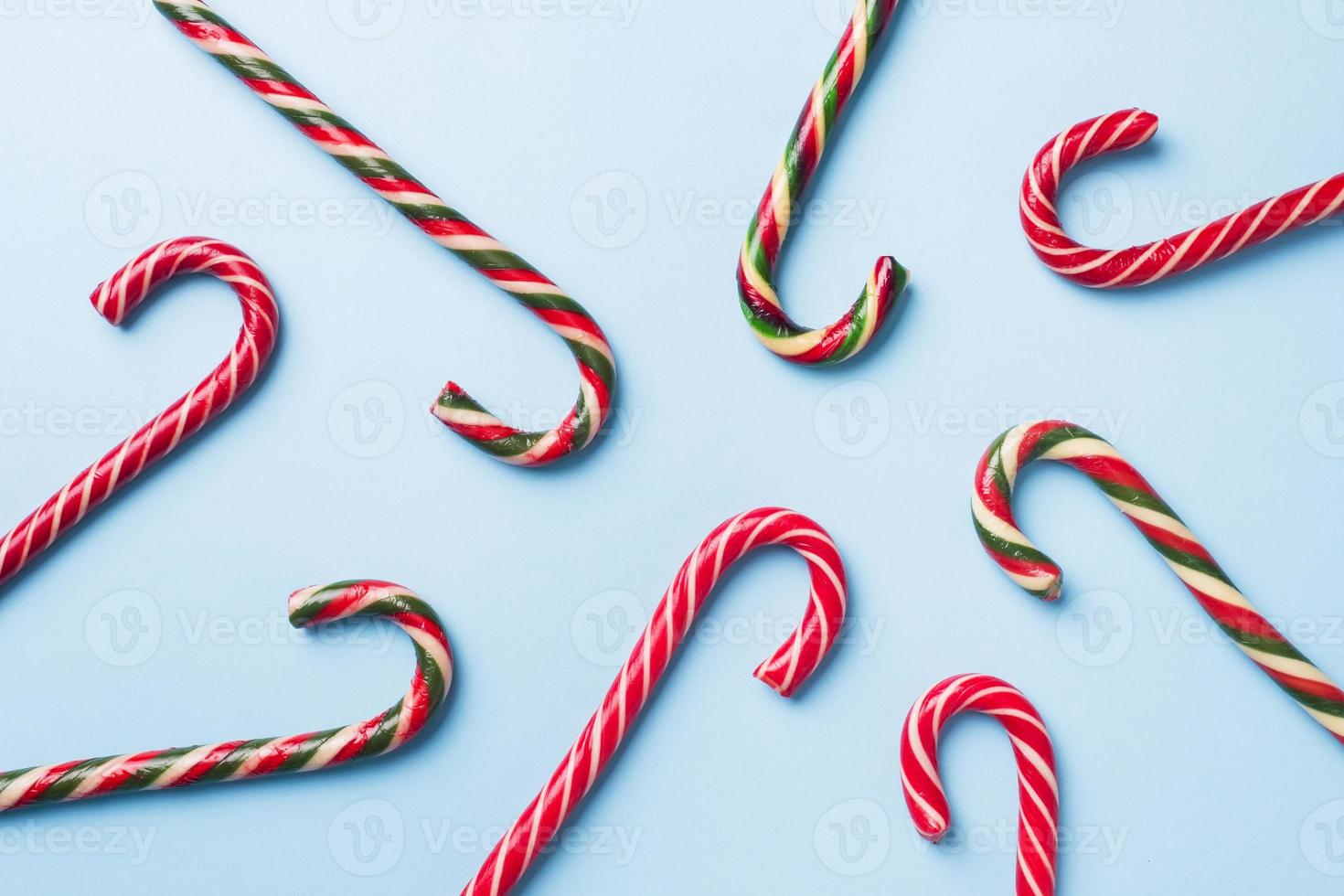 bastones de caramelo de Navidad sobre un fondo azul pastel. tarjeta de felicitación de celebración festiva con espacio de copia para agregar texto. foto