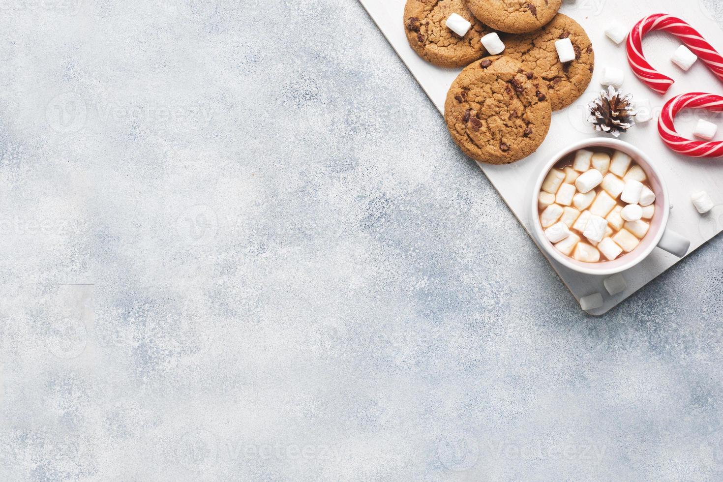 The chocolate chip cookie, Christmas cane caramel Cup cocoa and marshmallow cones Decorations on a gray background. Copy space Frame. photo
