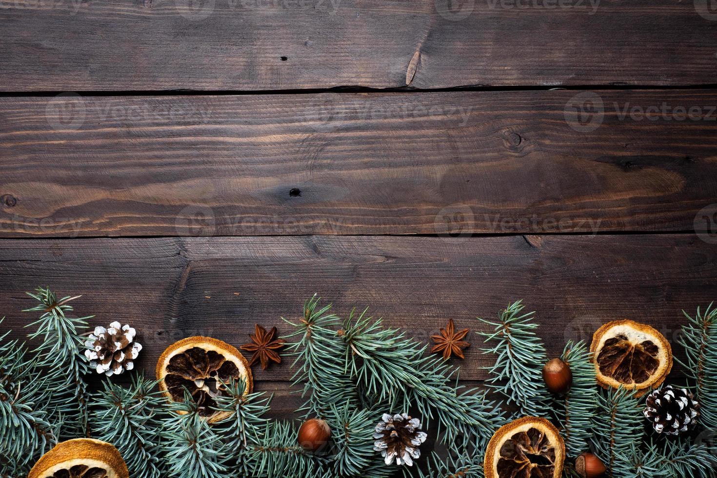 Frame of Christmas tree cones oranges nuts on dark wooden background. Copy space. Flat lay. photo
