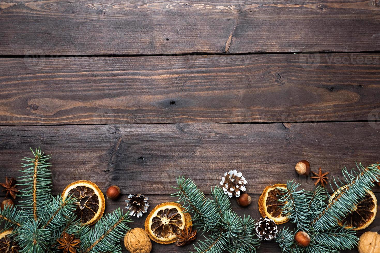 Frame of Christmas tree cones oranges nuts on dark wooden background. Copy space. Flat lay. photo