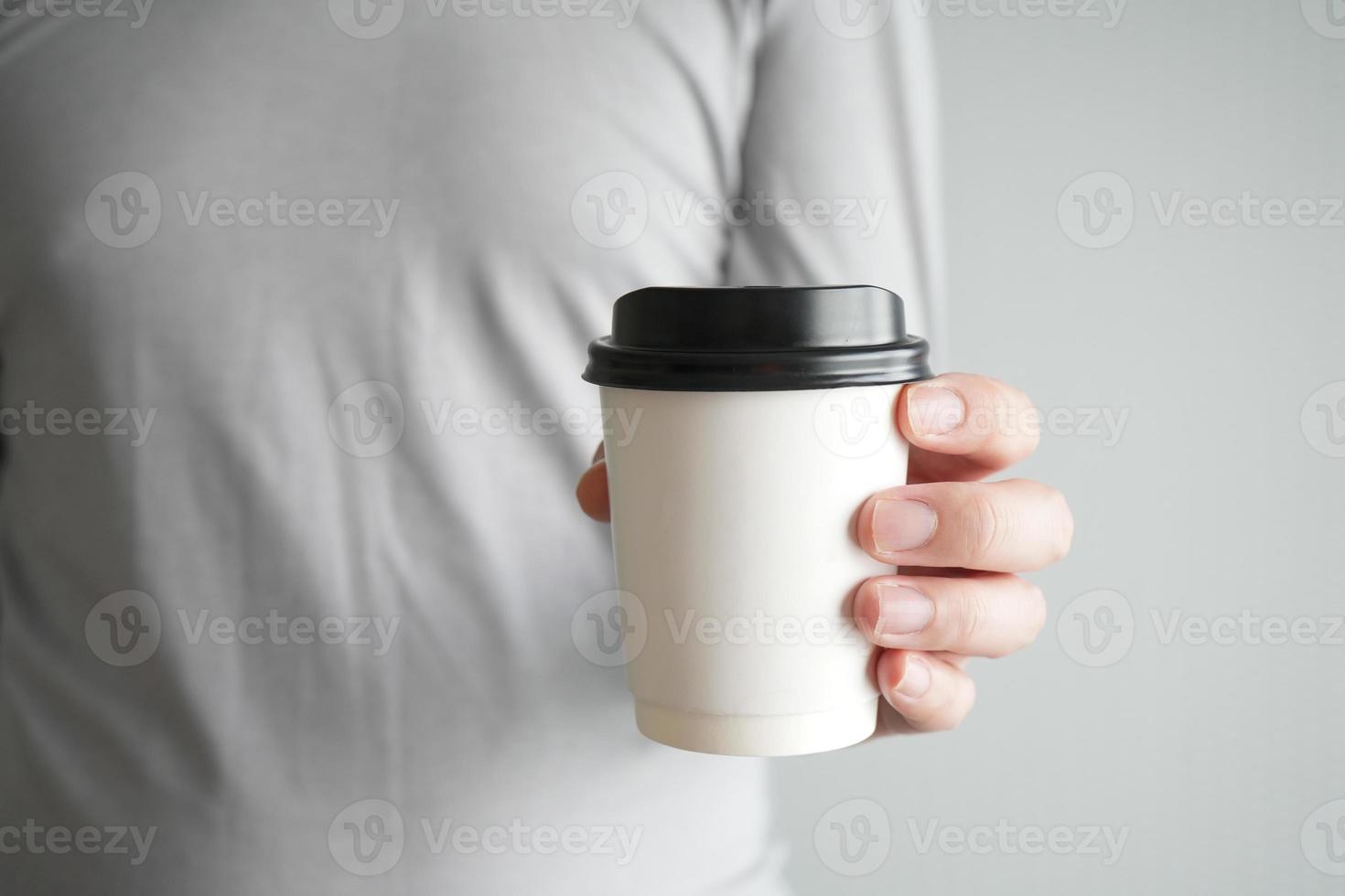 mano sosteniendo una taza de papel de café caliente. foto