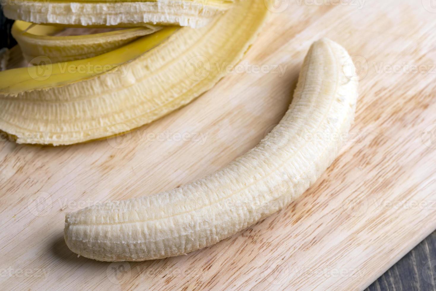 Peeled old ripe banana on the board photo