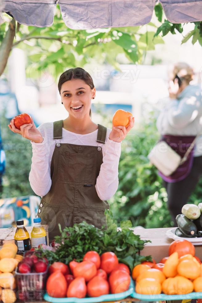 joven vendedora sosteniendo tomates de cosecha propia en las manos foto