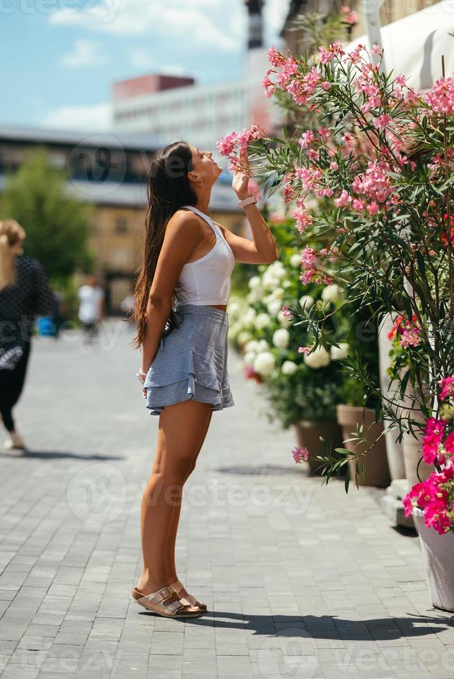 Outdoor portrait of young beautiful lady posing near flowering tree. photo