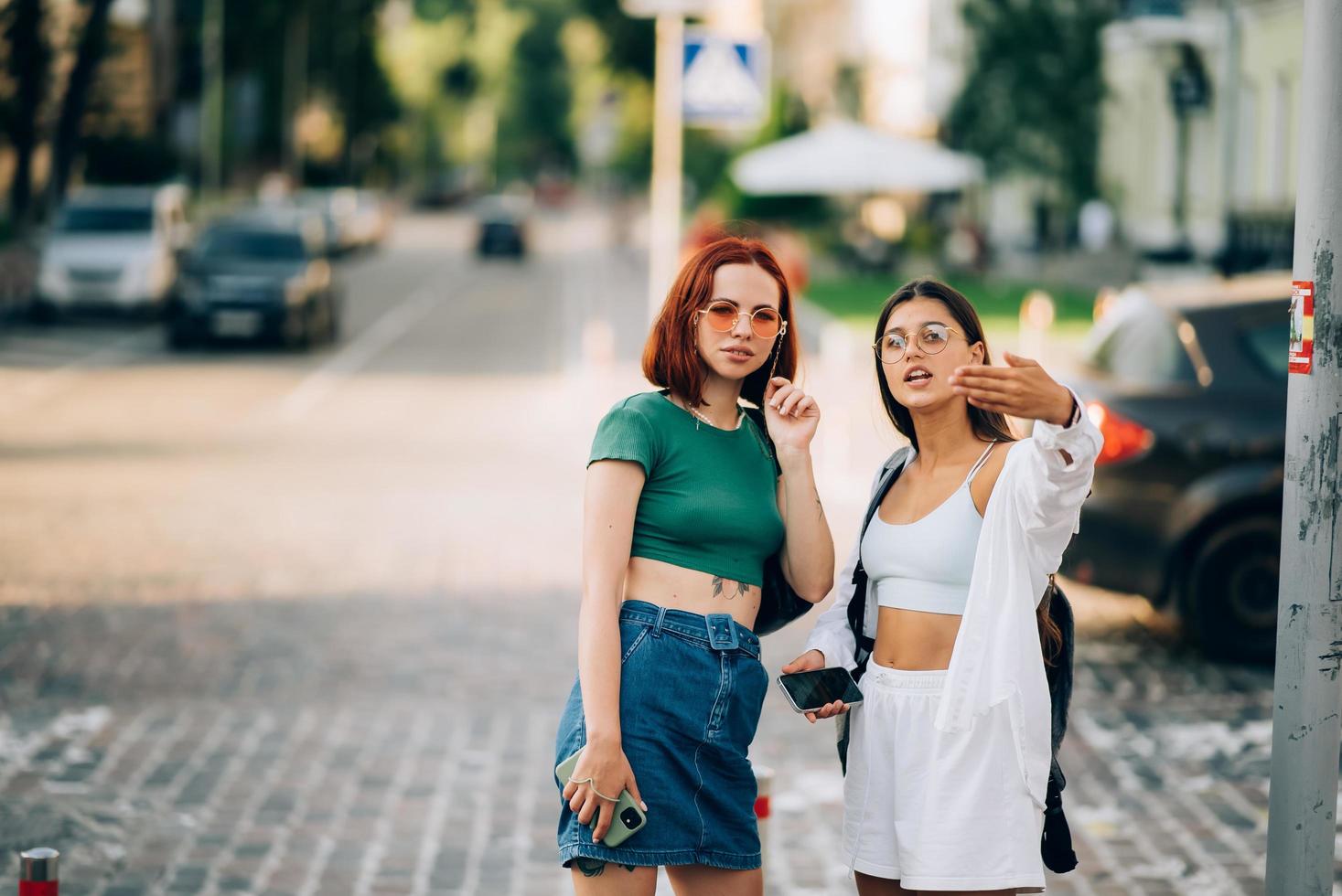 dos amigos turistas consultando una guía en línea en un teléfono inteligente en la calle foto