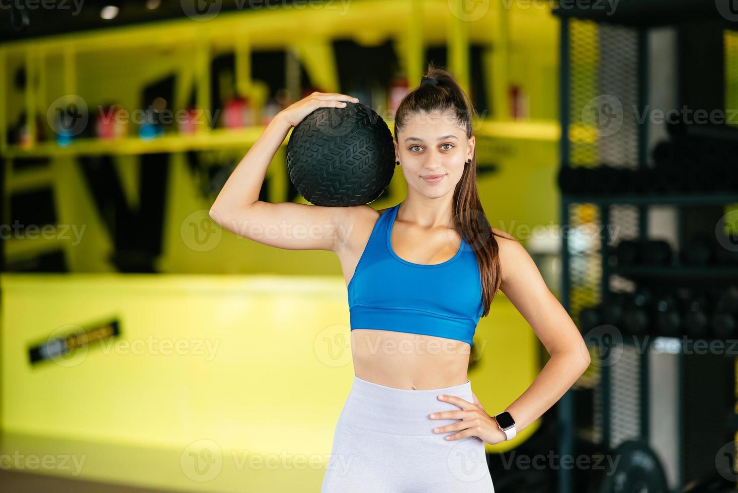 Young woman doing exercises with ball at the gym photo