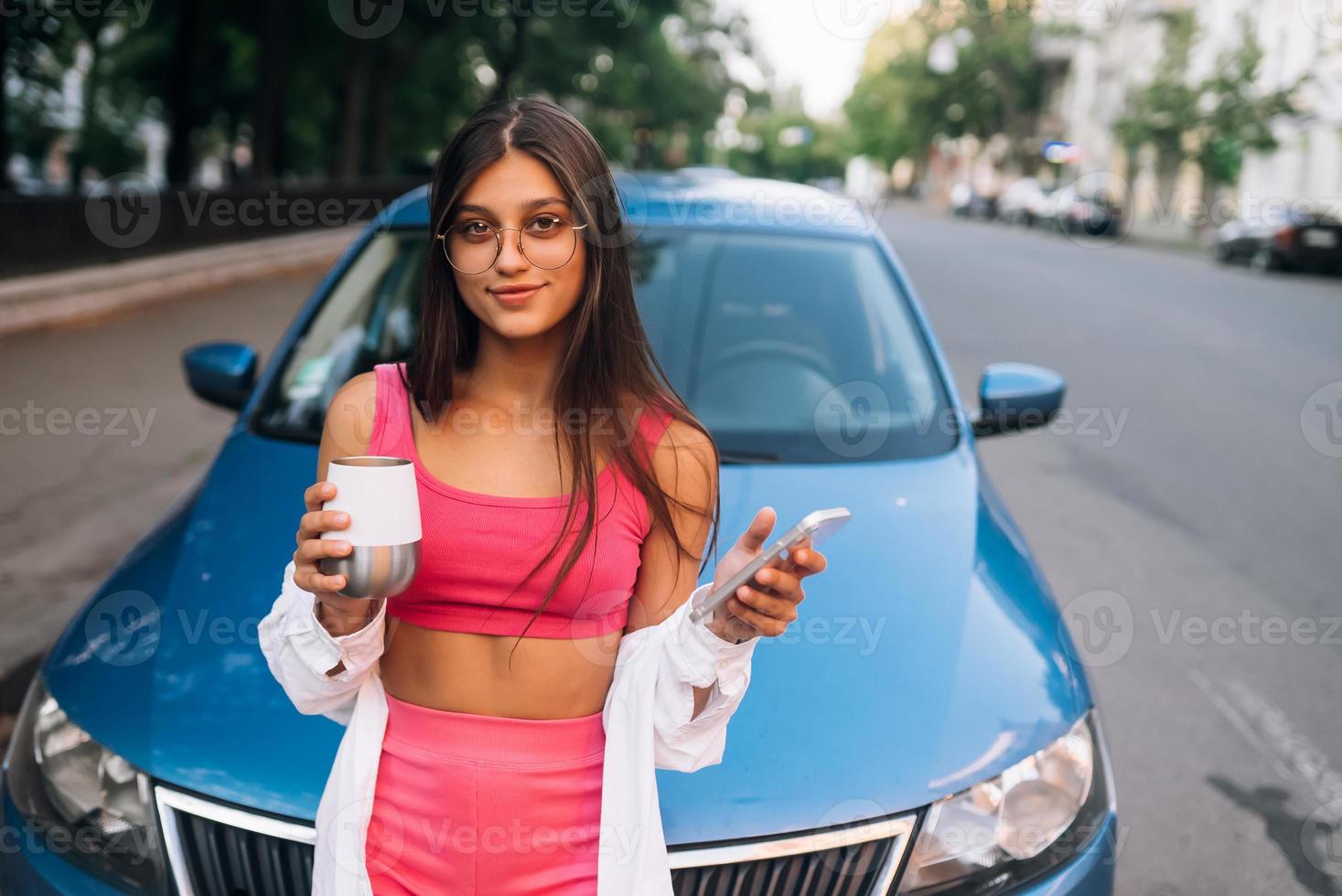 mujer conducir coche detener pausa para tomar café, usar teléfono inteligente foto