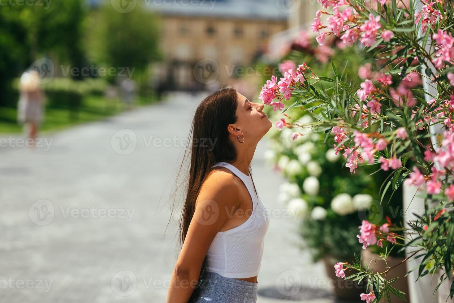 retrato al aire libre de una joven hermosa dama posando cerca de un árbol en flor. foto