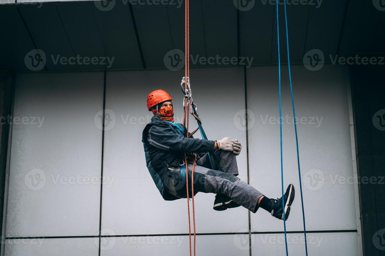 Industrial climber in uniform and helmet rises photo