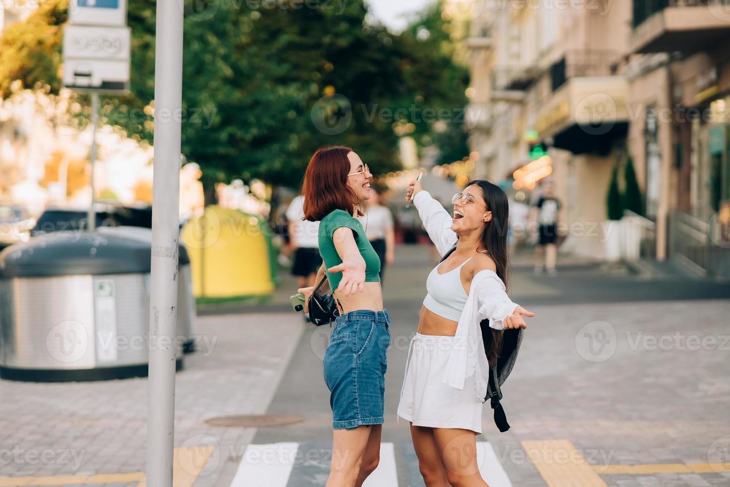 Happy meeting of two friends hugging in the street photo