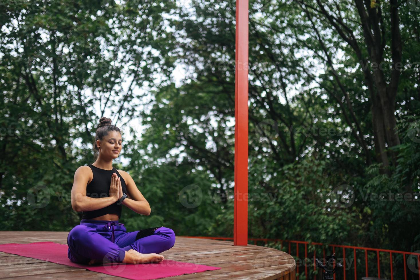 mujer joven está practicando yoga sentada en la posición de loto foto