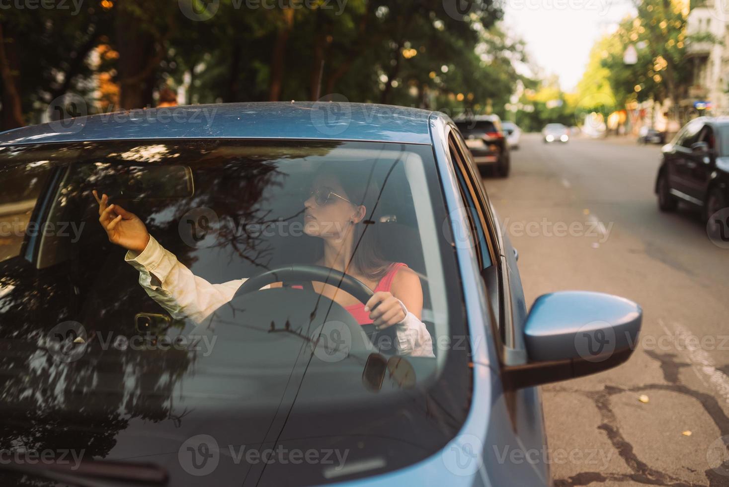 Gorgeous brunette fixing up rearview car mirror. photo