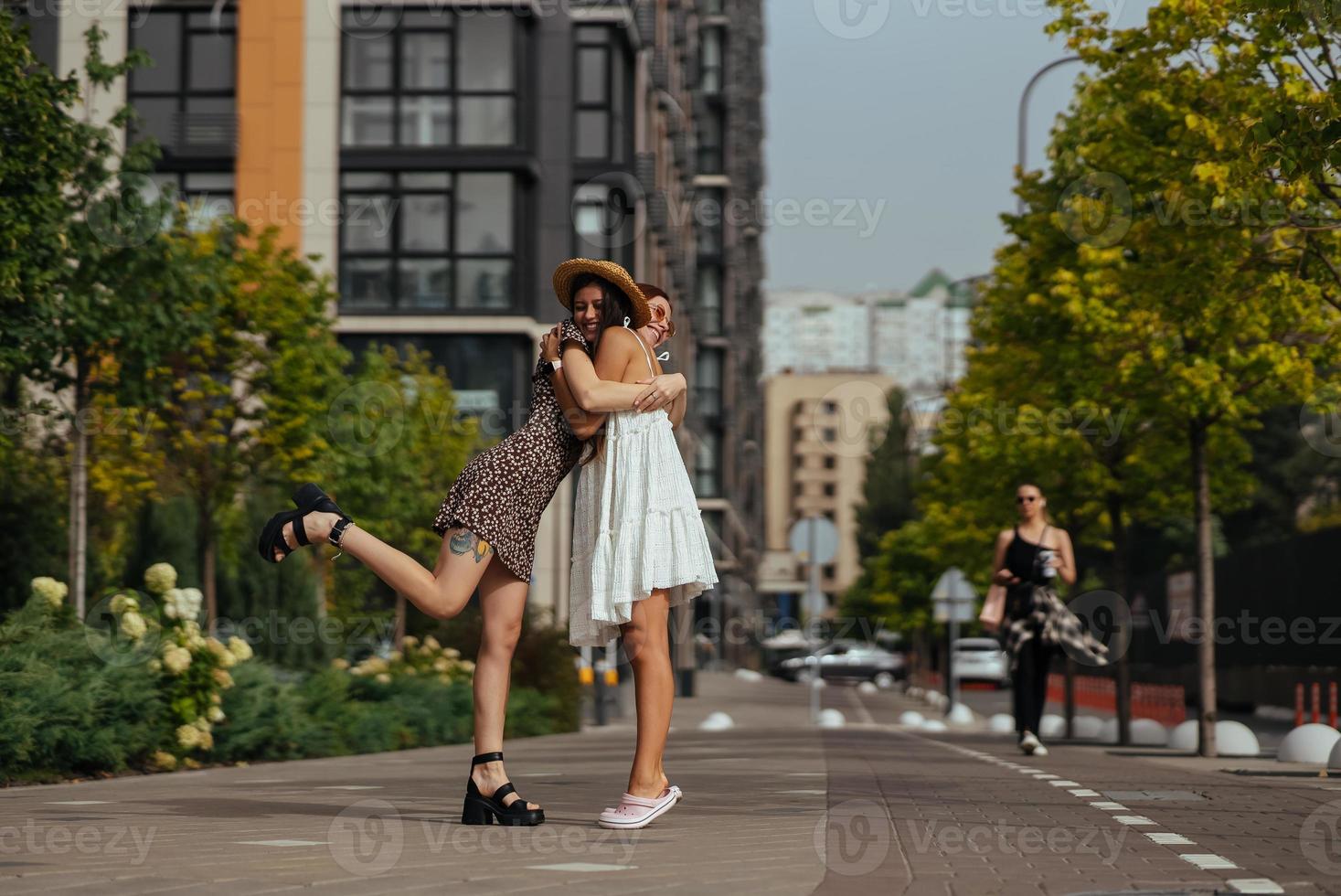 Happy meeting of two friends hugging in the street photo