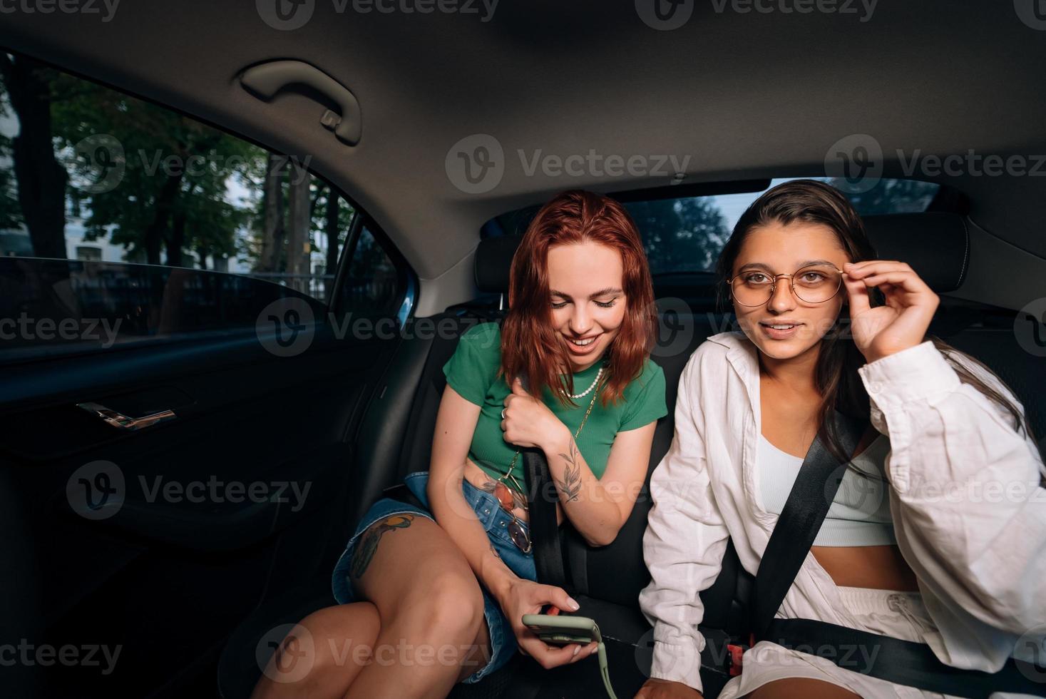 Friends together in the back seat of a taxi photo