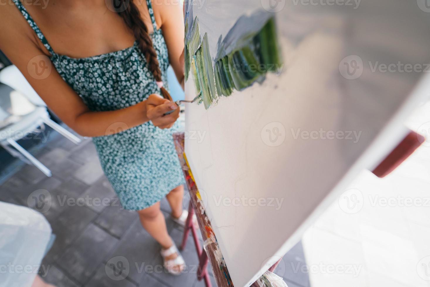 joven artista pinta con una espátula en el lienzo foto