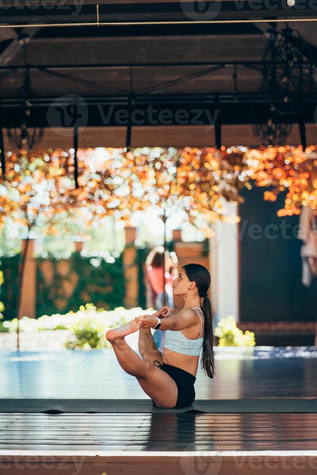 Young woman practicing yoga. Performs an exercise photo