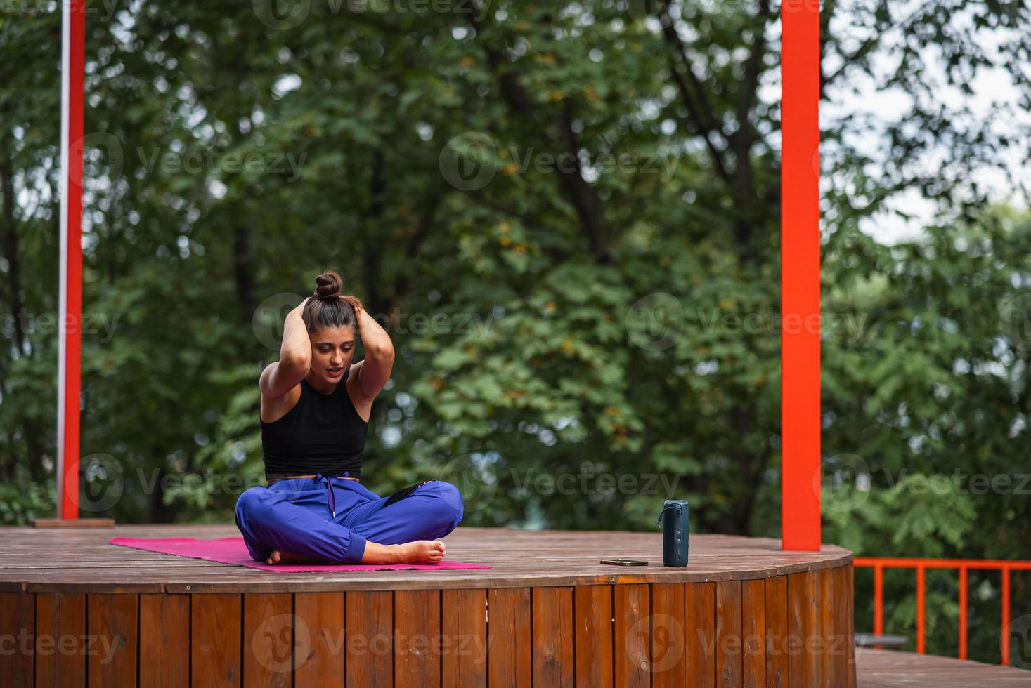 Young woman is practising yoga sitting in the lotus position photo