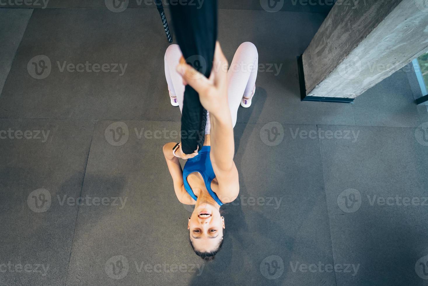 Young woman is climbing a rope in the gym photo