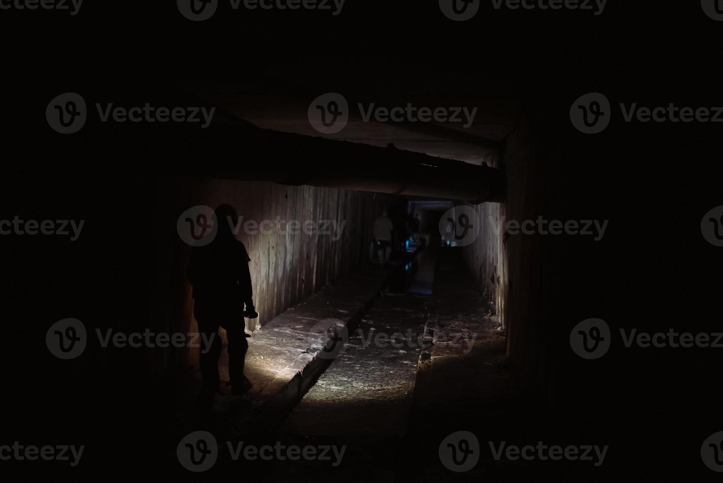 Female digger with flashlight explores the tunnel photo