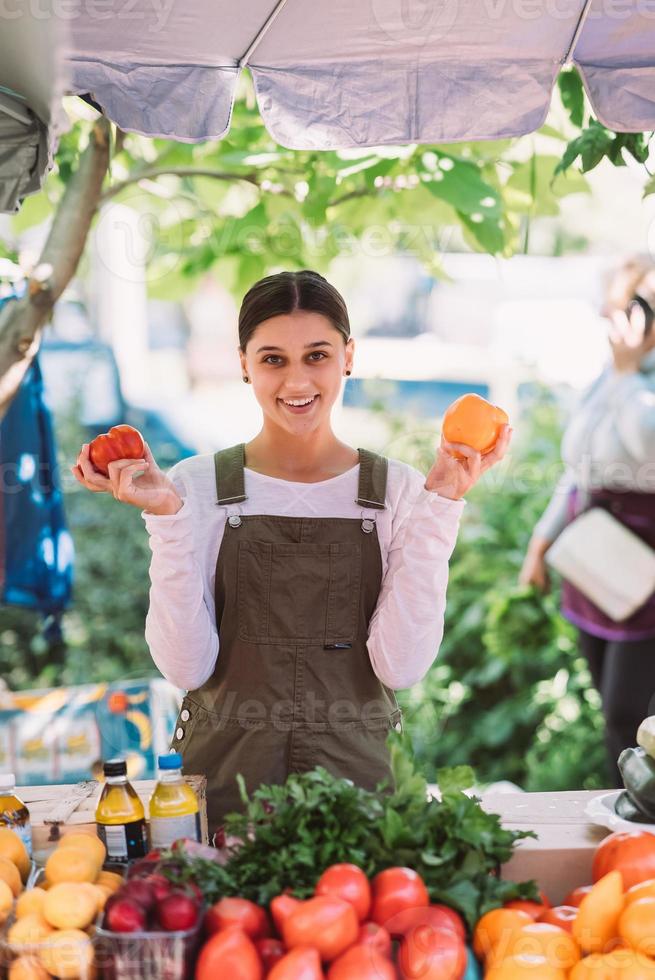 Young saleswoman holding home-grown tomatos in hands photo