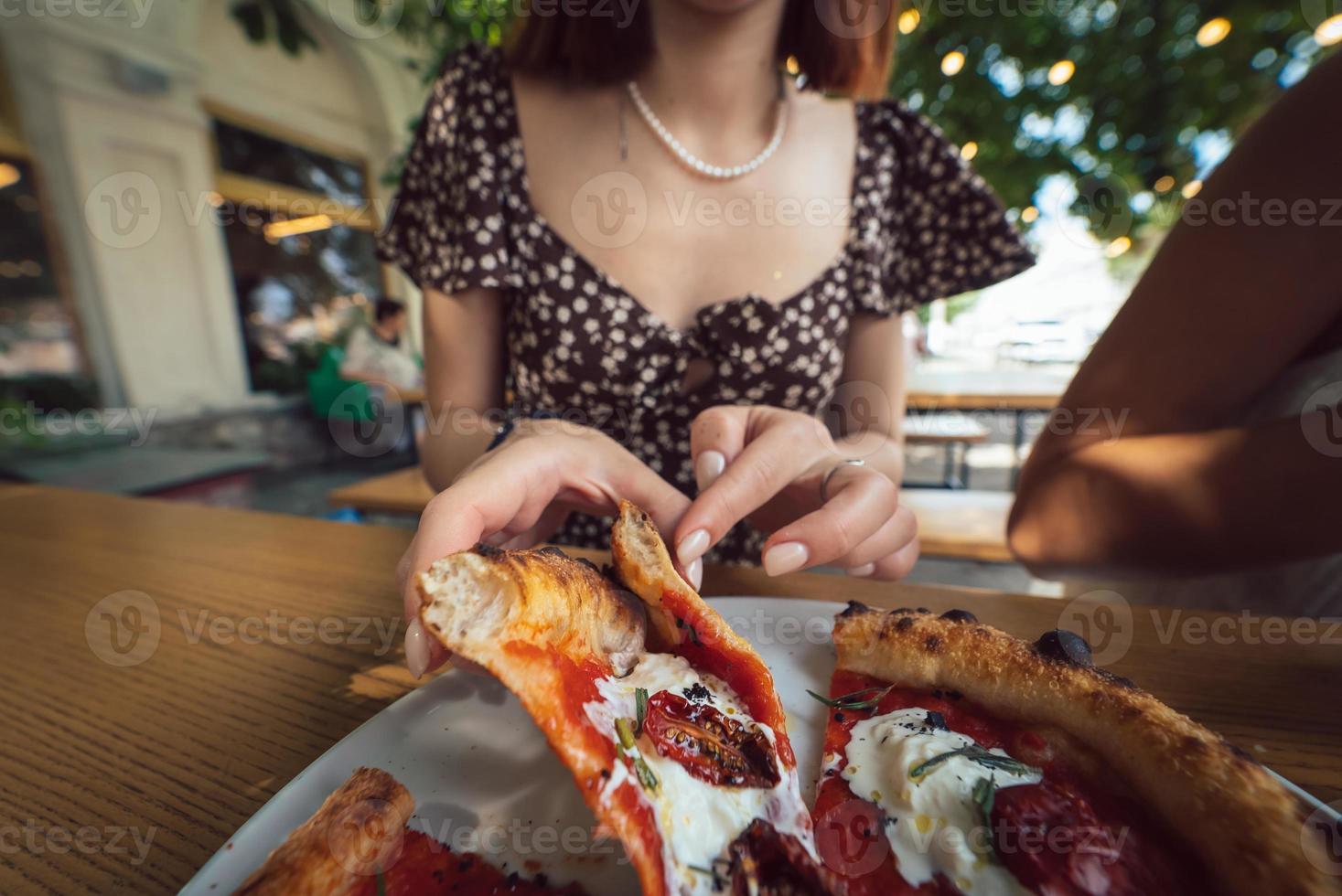 Charming beautiful woman takes a slice of pizza. photo