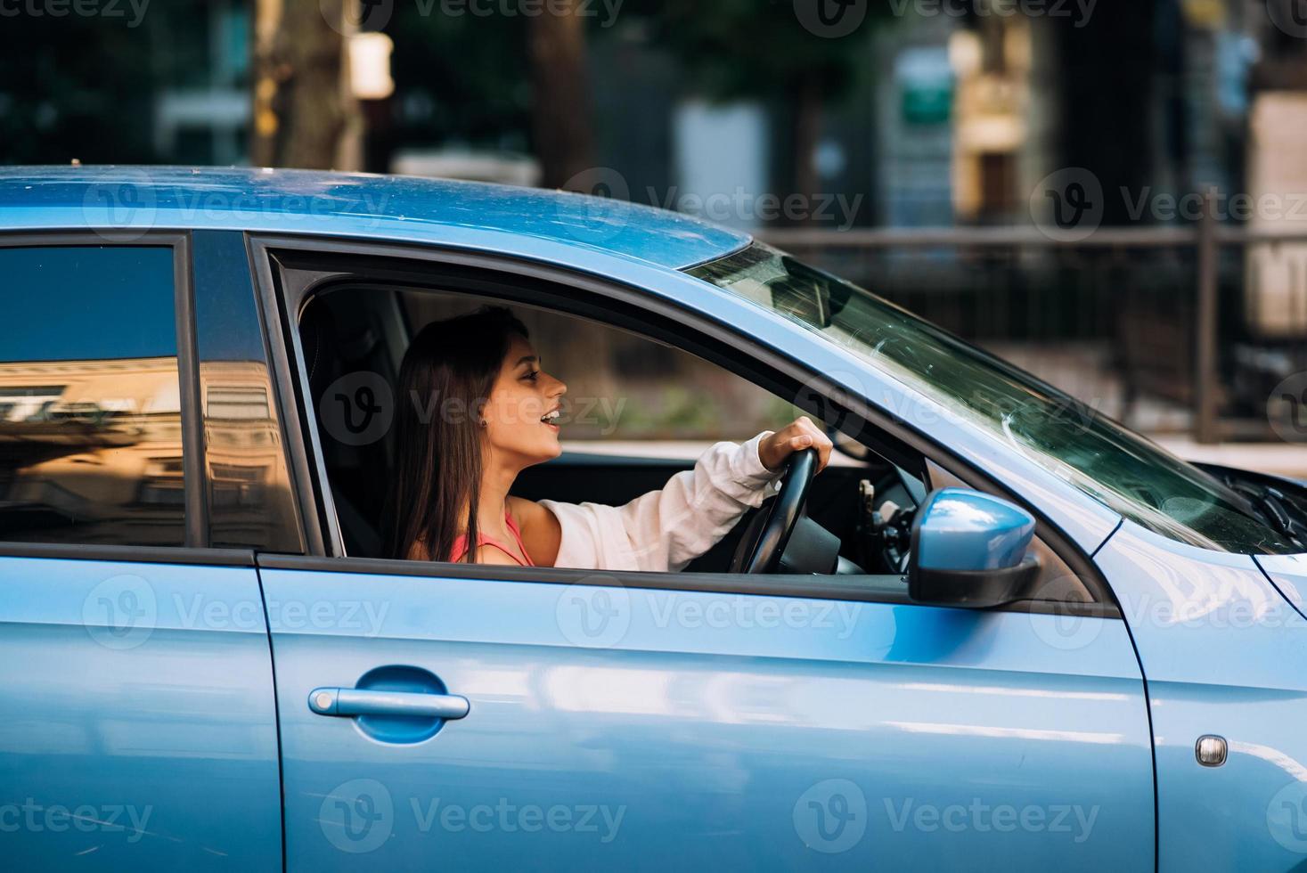 mujer sentada en el auto y usando su teléfono inteligente. foto