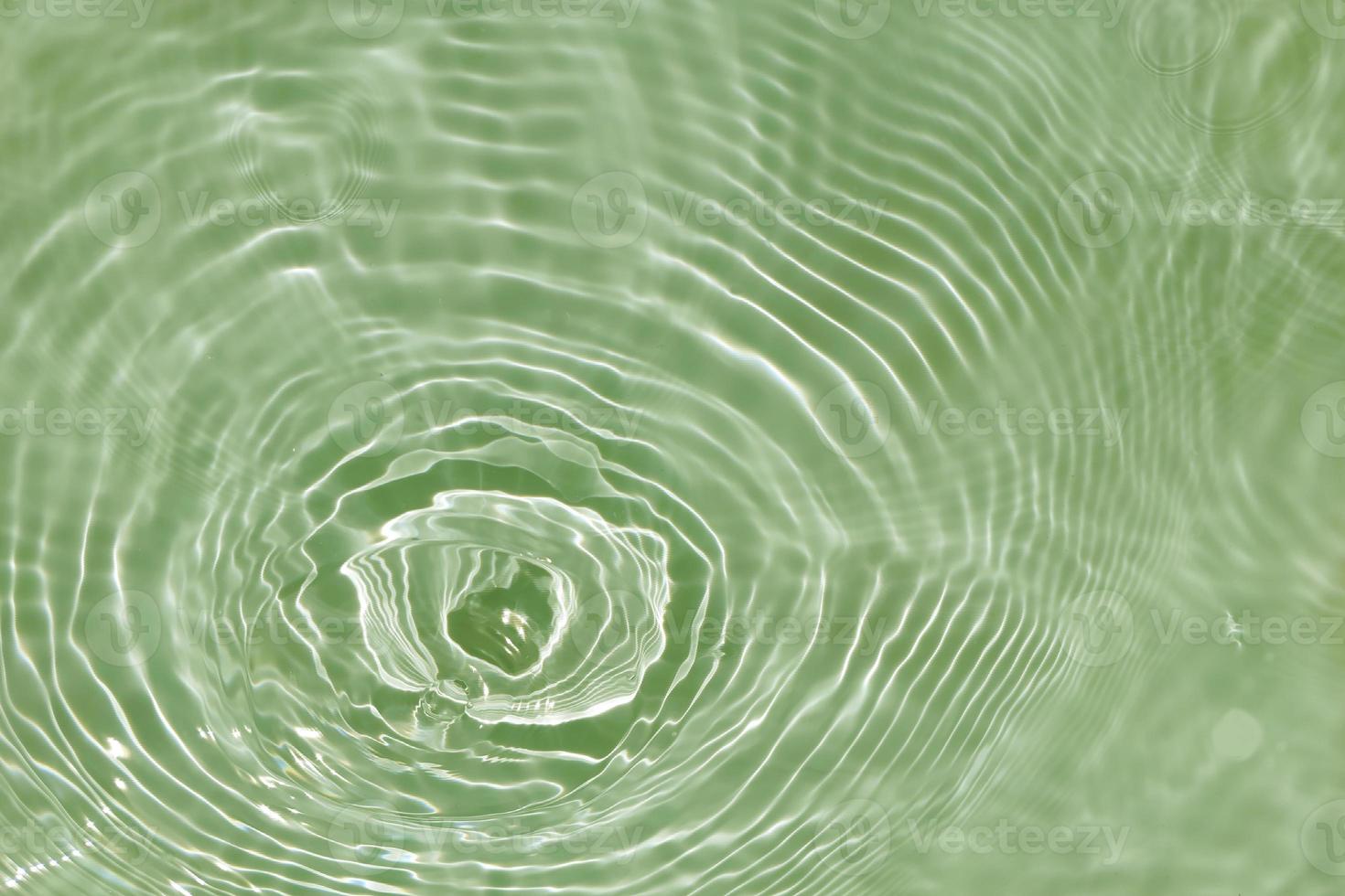 Defocus blurred transparent green colored clear calm water surface texture with splashes and bubbles. Trendy abstract nature background. Water waves in sunlight with copy space. Green watercolor shine photo