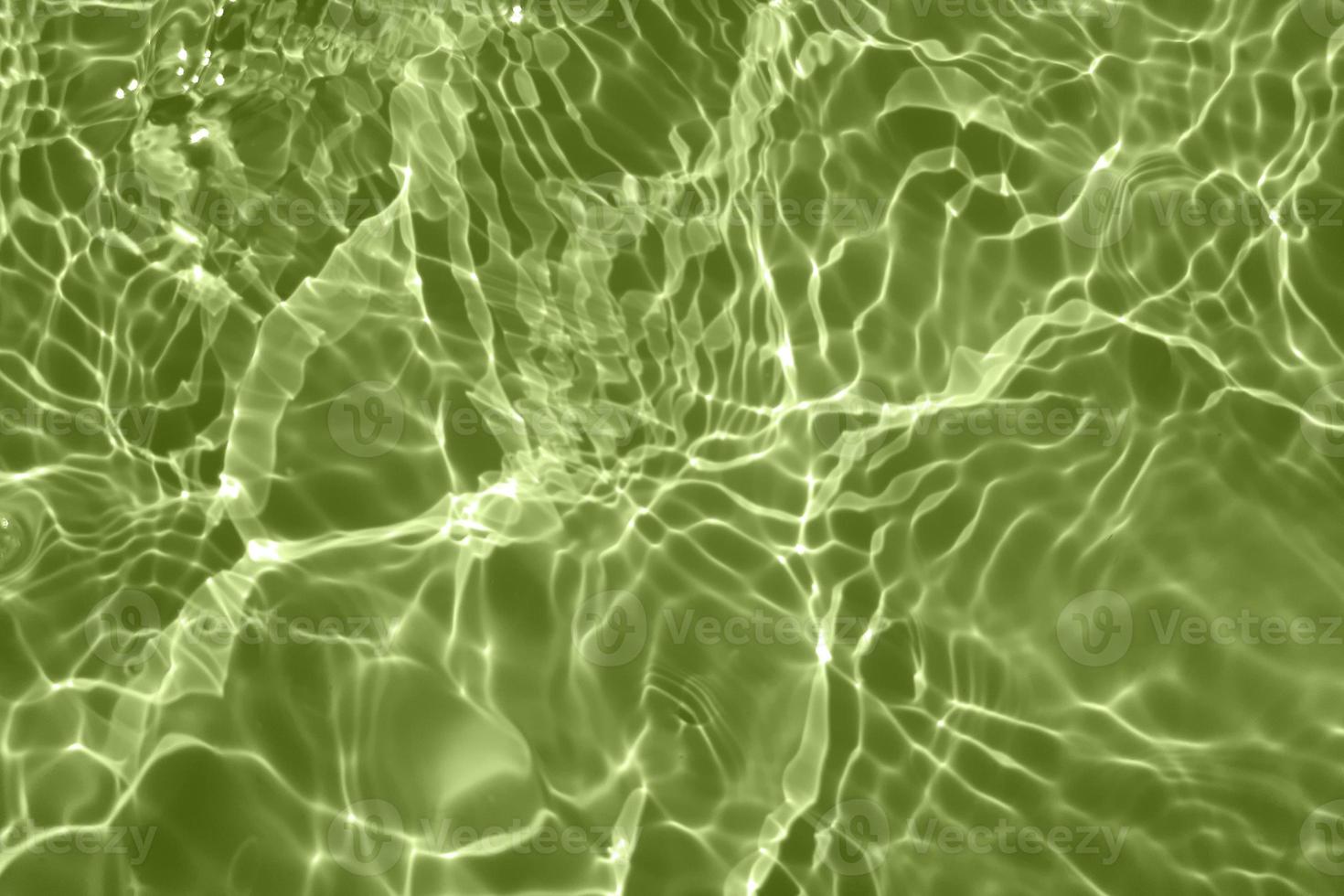Defocus blurred transparent green colored clear calm water surface texture with splashes and bubbles. Trendy abstract nature background. Water waves in sunlight with copy space. Green watercolor shine photo