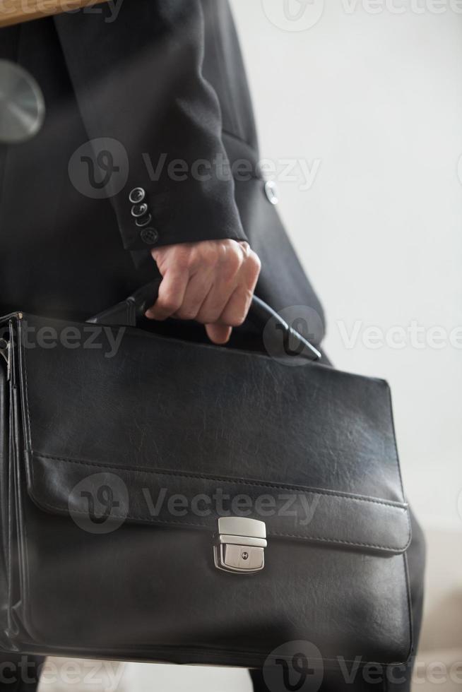 subiendo. imagen lateral recortada de un hombre con ropa formal que lleva un maletín y sube las escaleras foto