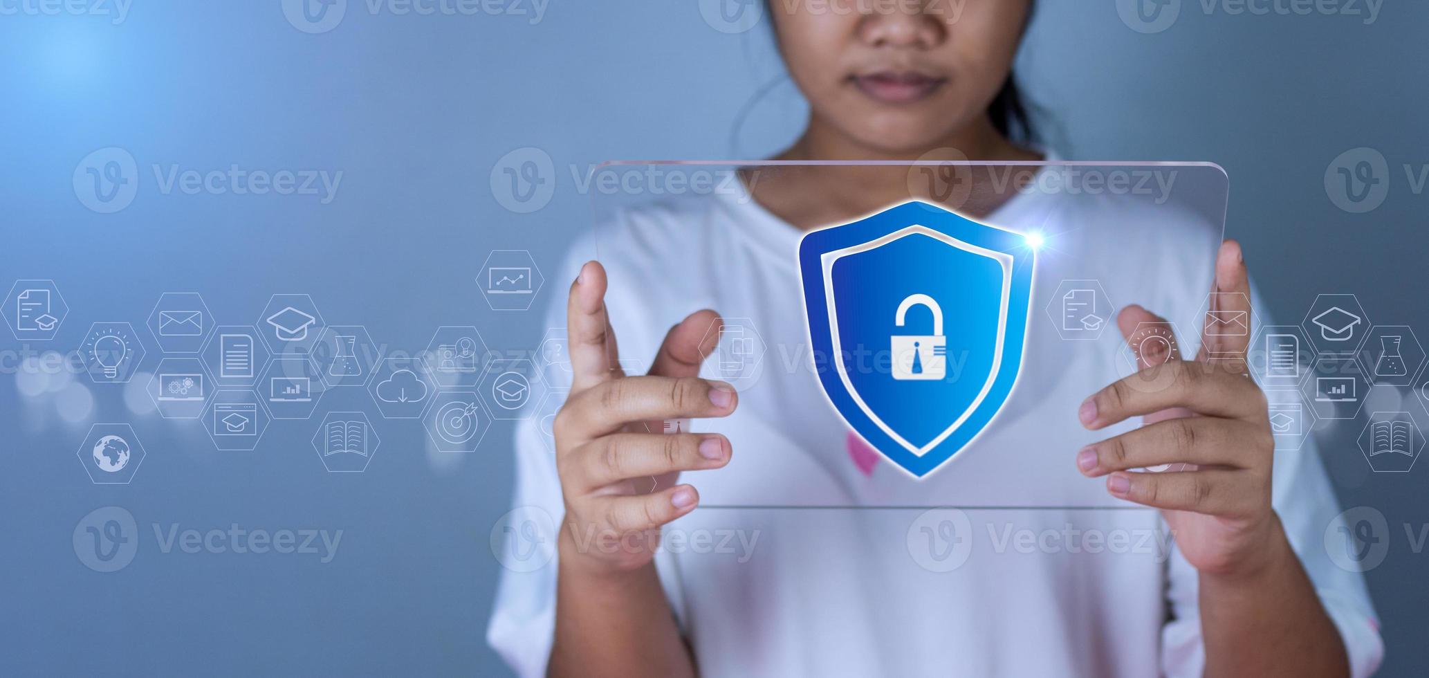Woman holding phone tablet screen with protection icon. Represents protection against external hacks. Security concepts against code, virus, firmware and malware. photo