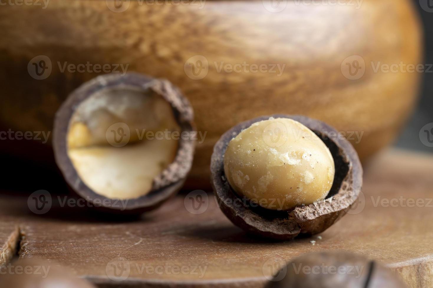 Unpeeled macadamia nuts on a wooden table photo