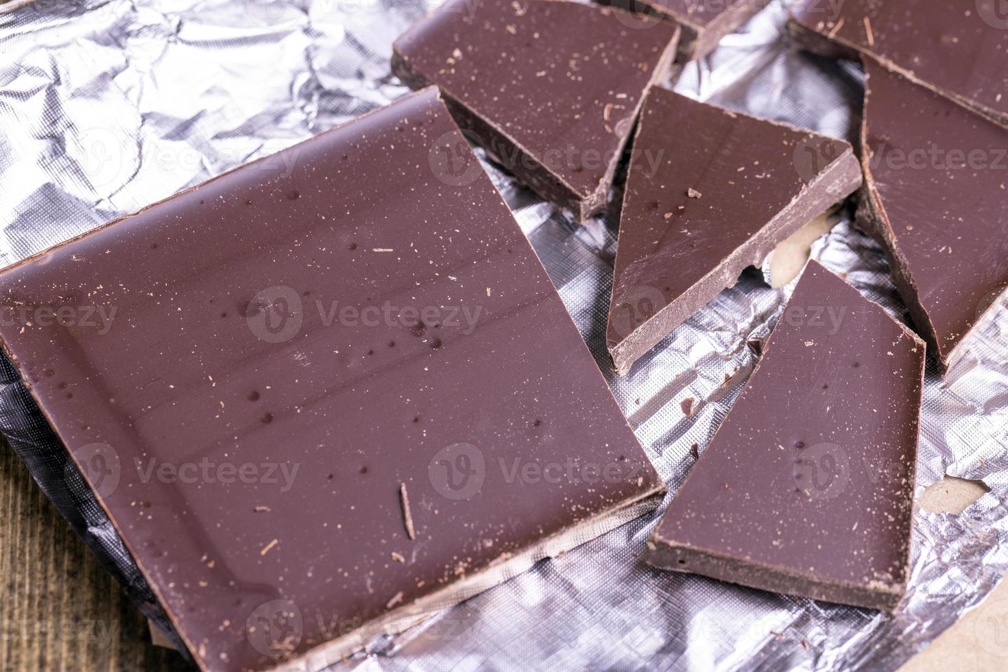 A broken chocolate bar in a paper and foil package photo