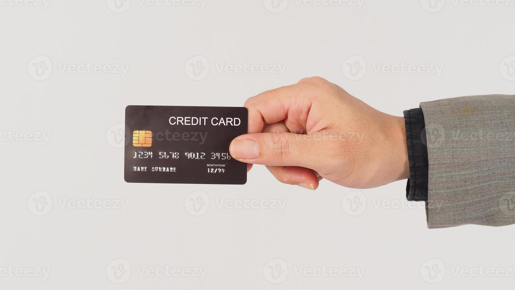 A hand is holding black credit cards and wearing suit on white background. photo