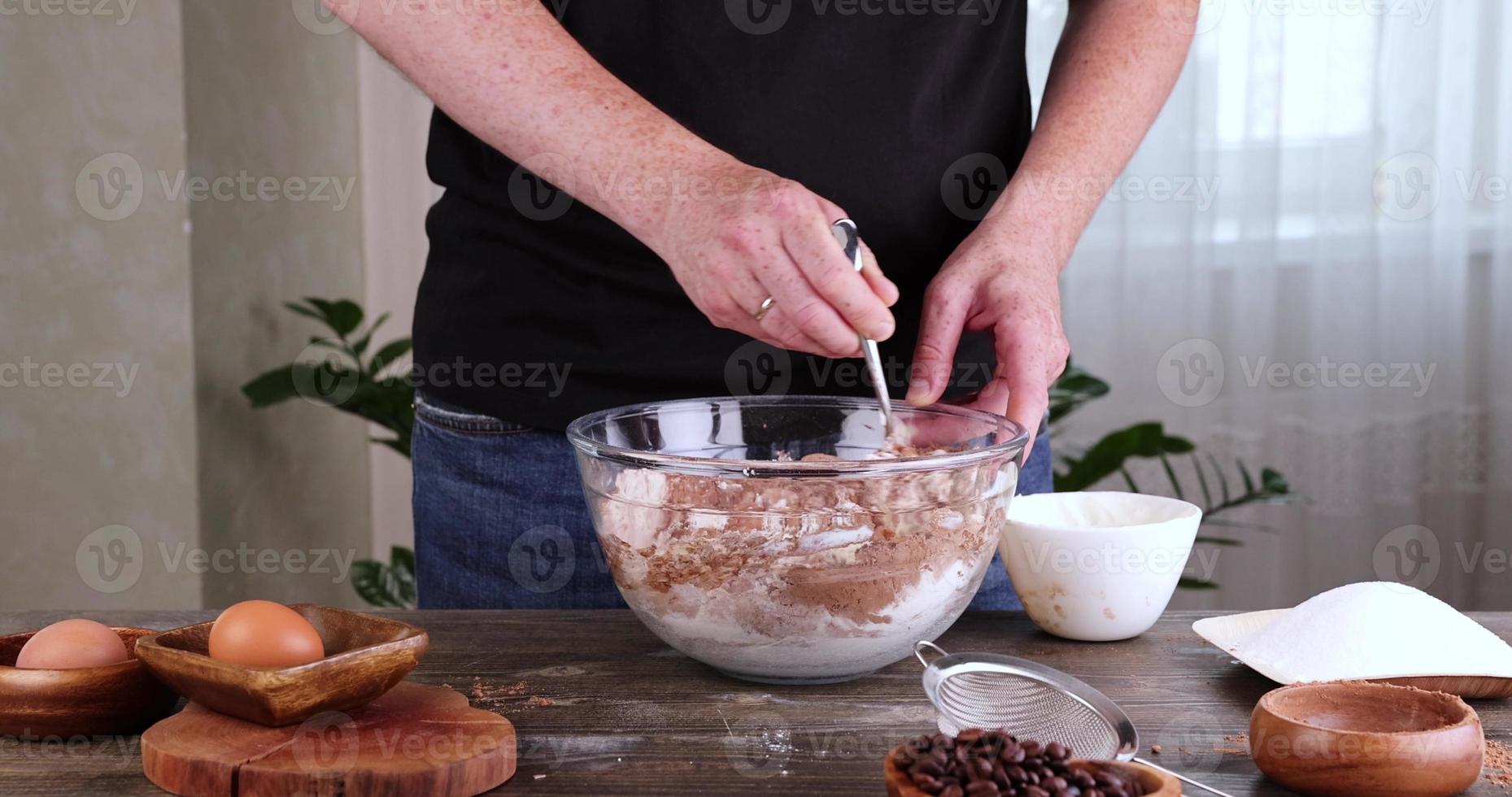 A man mixes flour with sugar and cocoa photo