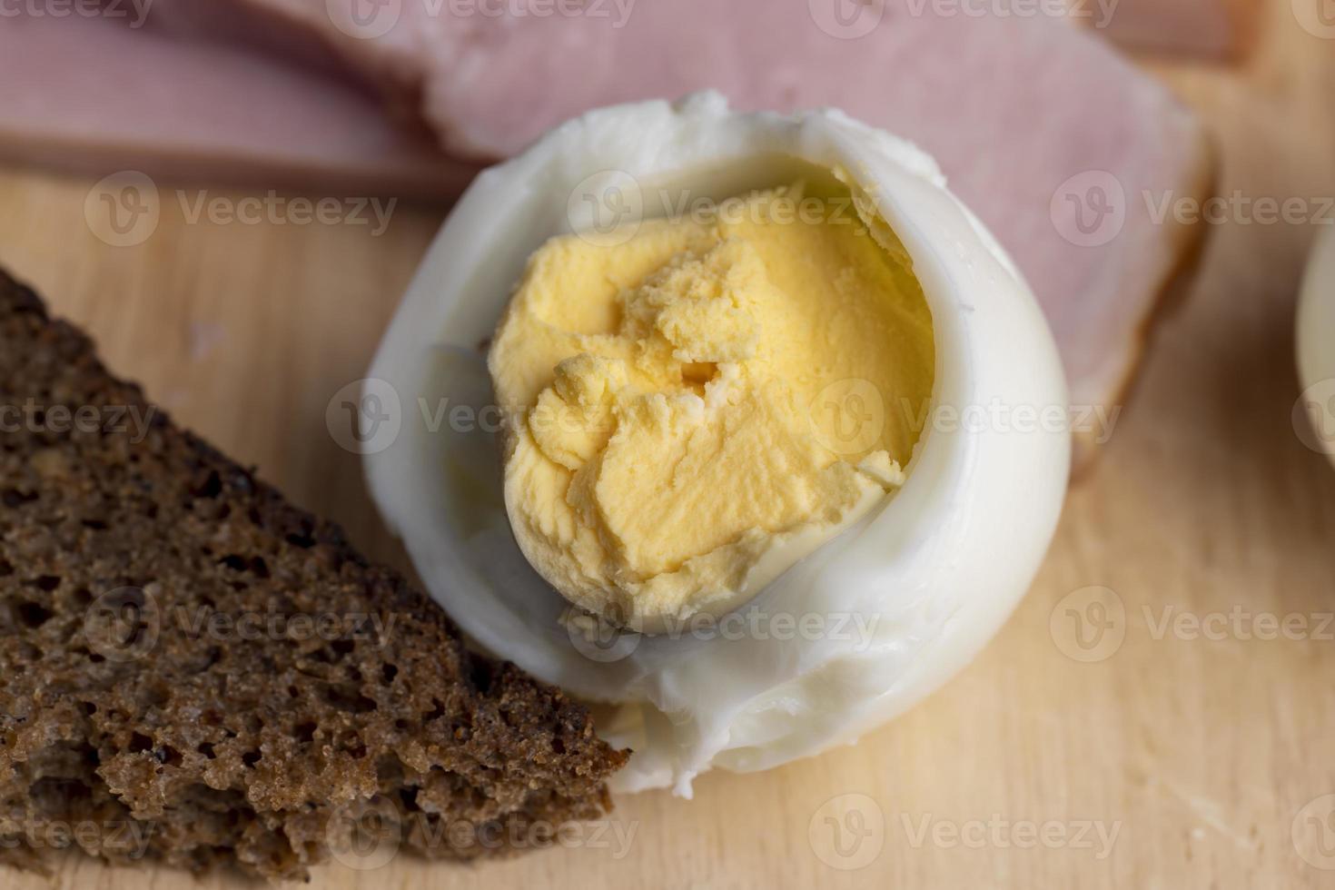 Boiled chicken egg with sliced pieces of meat photo