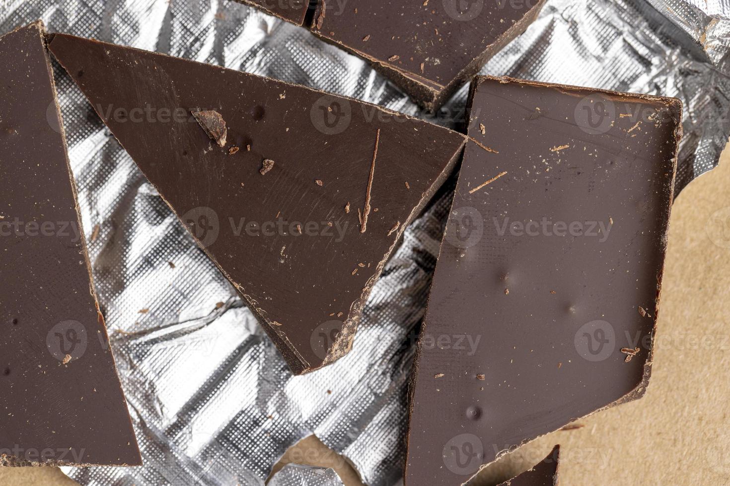 A broken chocolate bar in a paper and foil package photo
